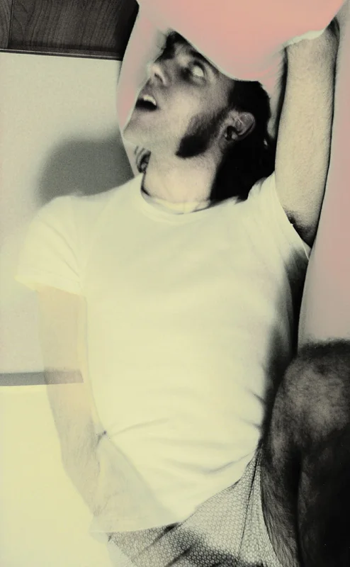 Young man in a white T-shirt, head thrown back and mouth open, one arm raised